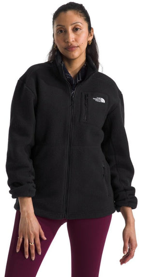 A woman wearing a black fleece jacket with a zipper and a breast pocket, paired with burgundy leggings.