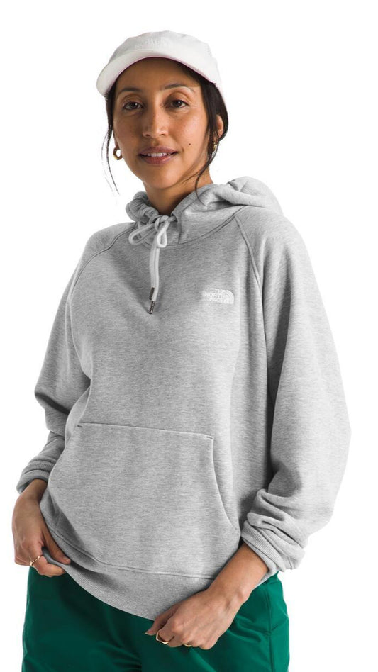 A woman in a white cap and grey hoodie with a kangaroo pocket.