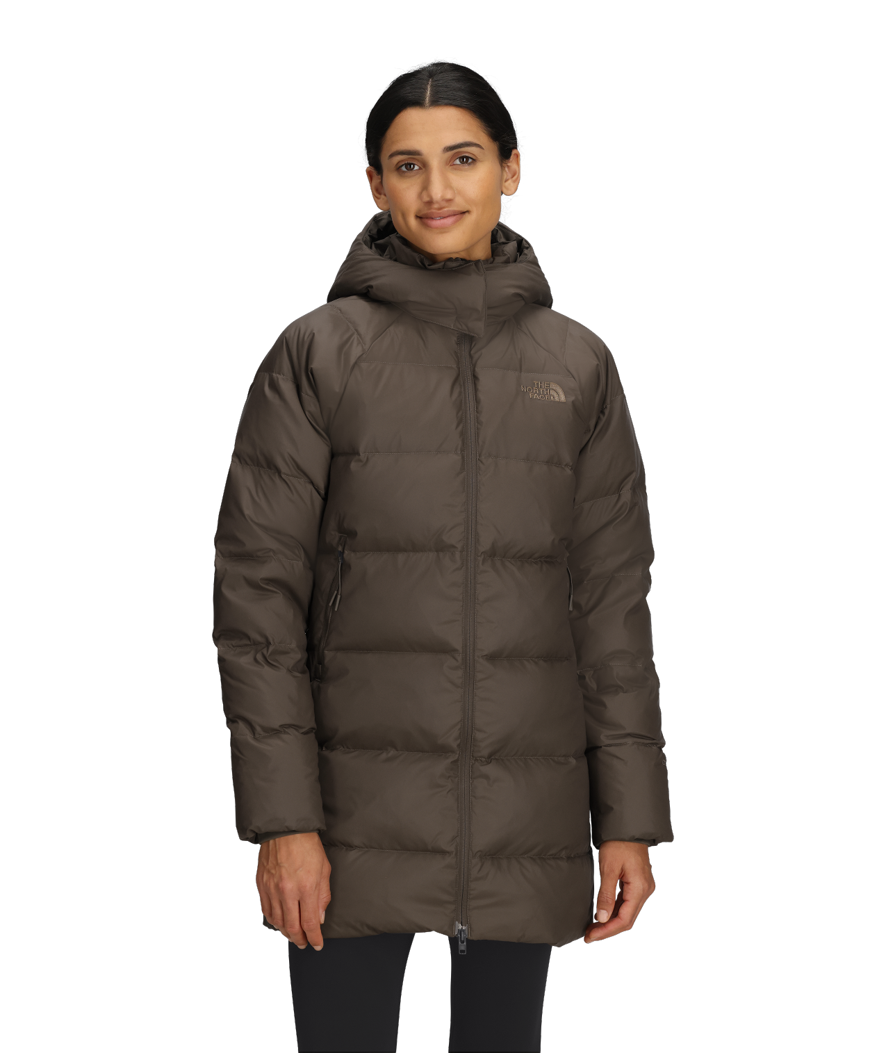 A person wearing a brown, knee-length puffer coat with a hood.