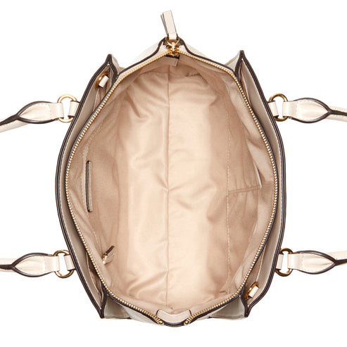 An overhead shot of the interior of a beige tote bag with two handles.