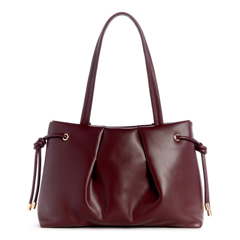 A burgundy faux leather tote bag with handles and knot details on the sides.