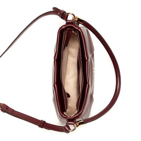 Burgundy padded handbag with a zipper, and a thin shoulder strap.