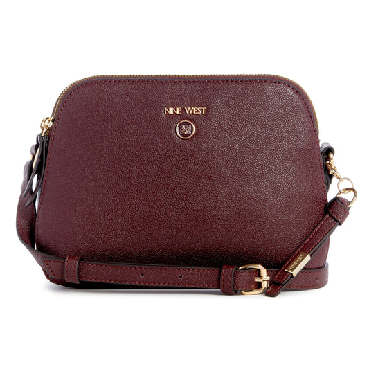 Burgundy dome shaped cross-body purse with gold hardware and adjustable strap. The text 'NINE WEST' and a round logo are on the front.