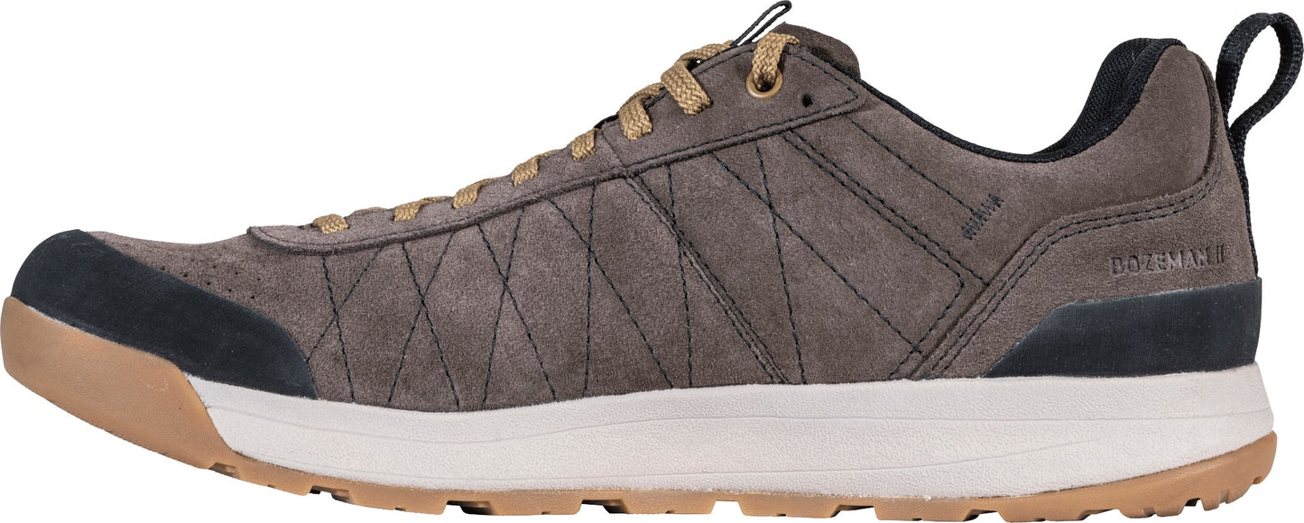 A gray suede low-top athletic sneaker with a diamond-stitched pattern on the side, tan laces, a black rubber toe cap, a thick white midsole, and a tan rubber outsole.