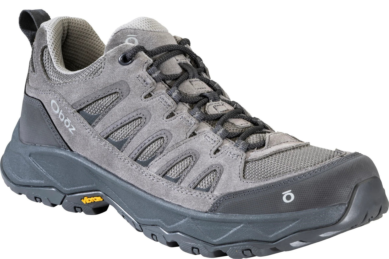 A gray low-cut Oboz hiking shoe with suede and mesh upper, black laces, dark gray sole with Vibram yellow logo on the side, and a rubber toe cap.