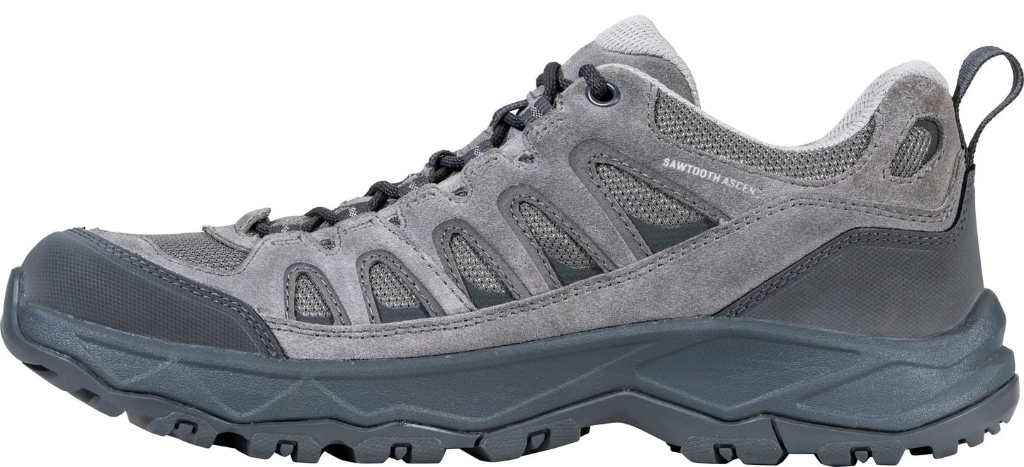 A gray low-cut hiking shoe with a suede upper, mesh panels, dark gray rubber toe cap, and a lugged outsole, with the text 'SAWTOOTH ASCENT' visible on the side.