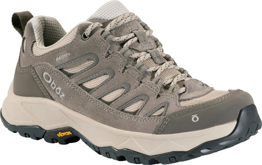 A low-top, taupe-colored suede hiking shoe with a breathable mesh tongue, lace-up closure, B-DRY branding on the side, a thick beige midsole, and a dark, treaded Vibram outsole.