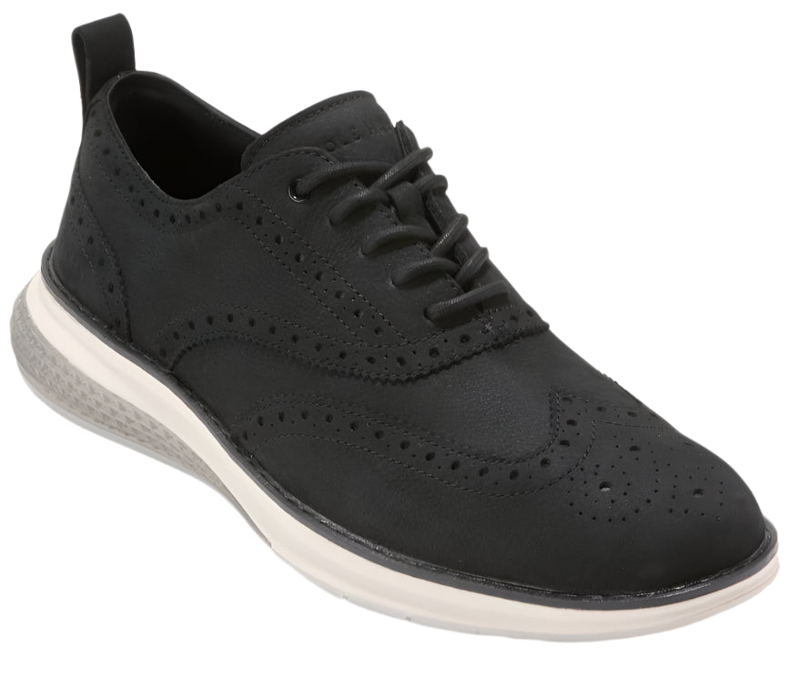 A black, lace-up shoe with brogue detailing and a thick, white sole.
