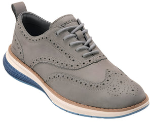 Grey leather oxford shoe with brogue detailing and a contrasting blue and white sole; 'COLE HAAN' visible on the tongue.