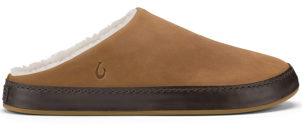 A tan slip-on shoe with a shearling lining and a dark brown leather wrapped midsole with a small embossed hook logo on the side.