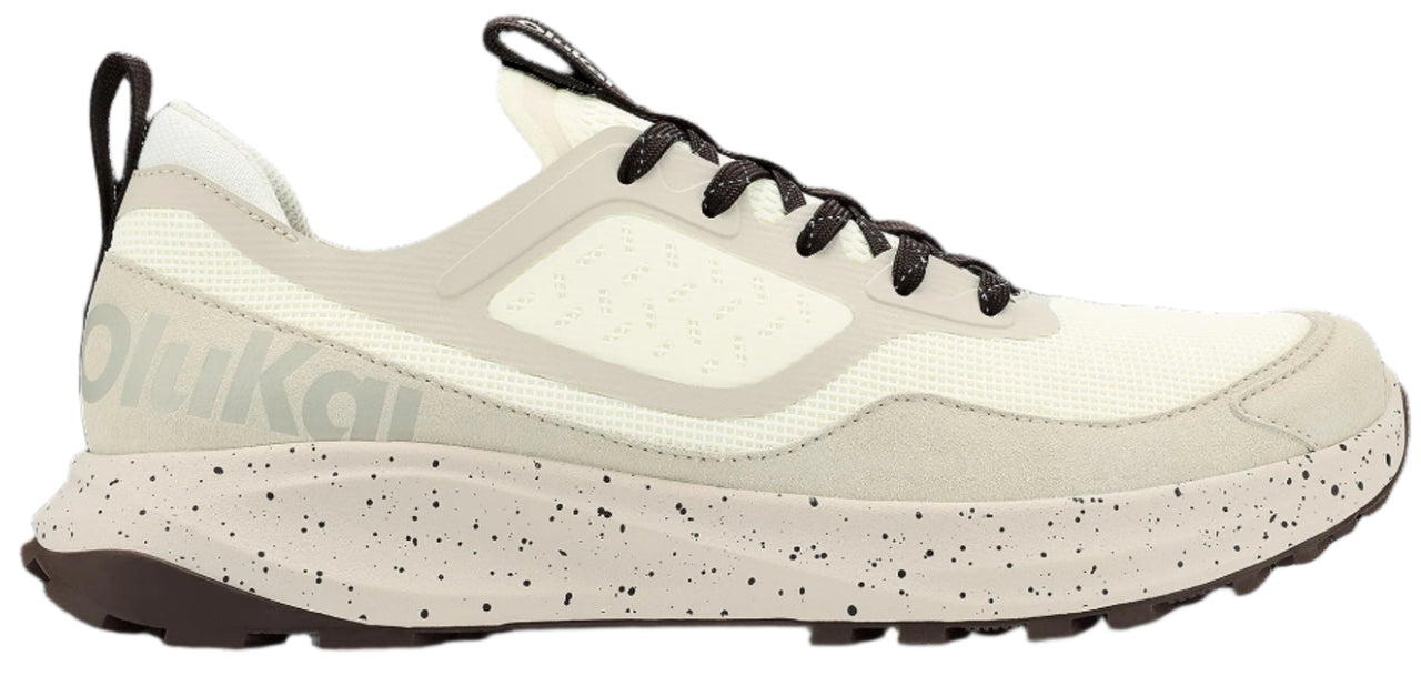 A running shoe with a speckled off-white sole, light-colored upper, and black laces.