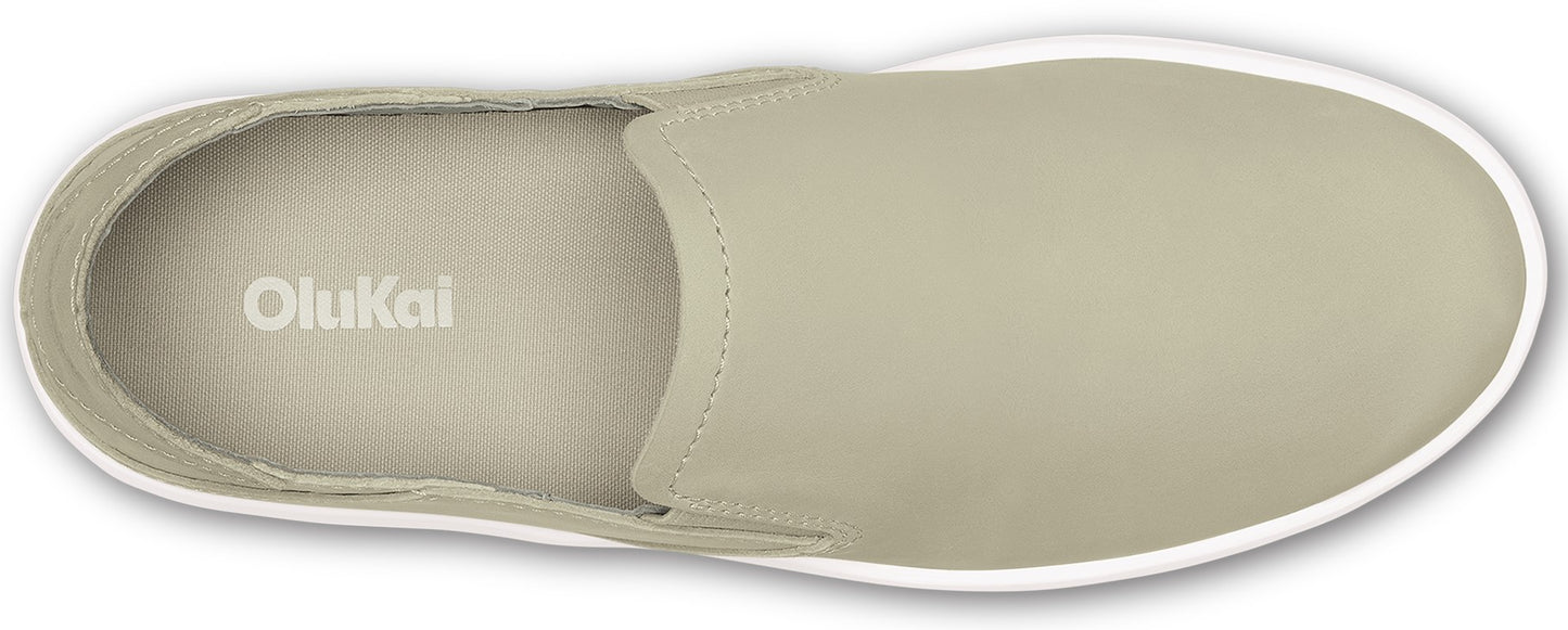 An overhead view of a taupe-colored slip-on shoe with a white sole and the word "OluKai" inside.