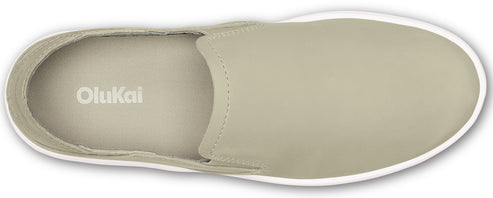 An overhead view of a taupe-colored slip-on shoe with a white sole and the word "OluKai" inside.
