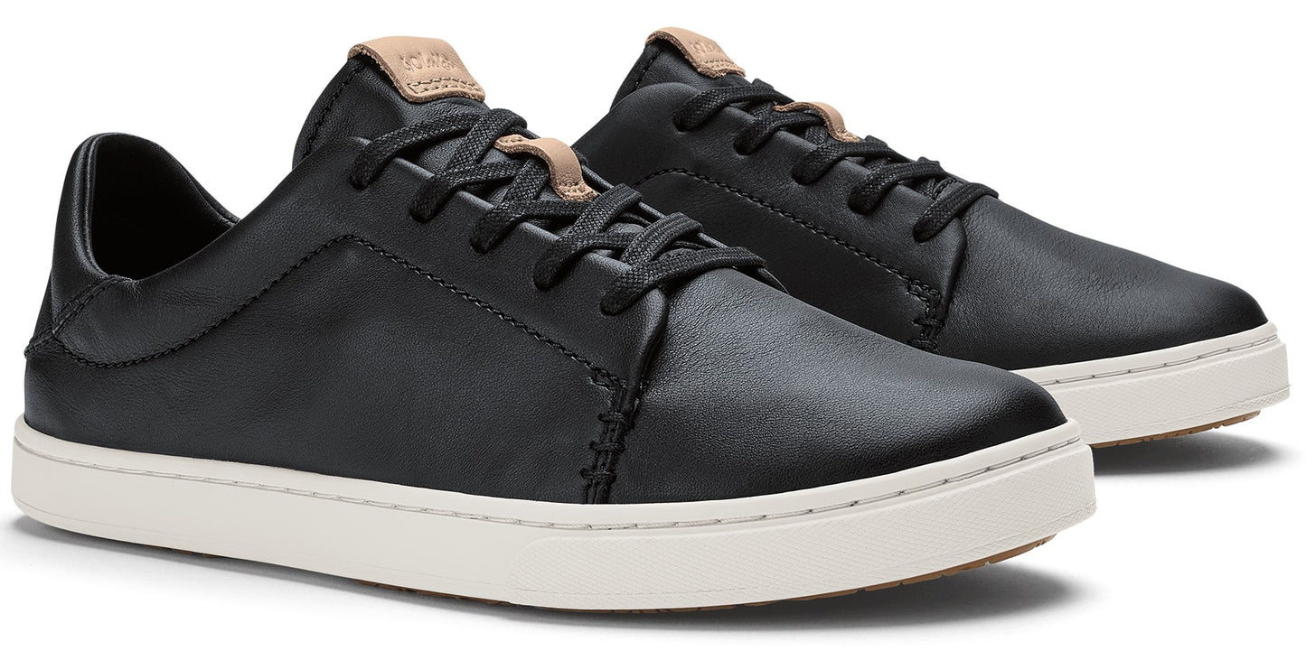A pair of black low-top sneakers with black laces and tan accents on the tongue.