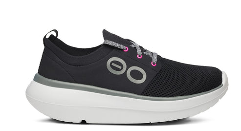 A black sneaker with gray and pink laces and a thick white sole.
