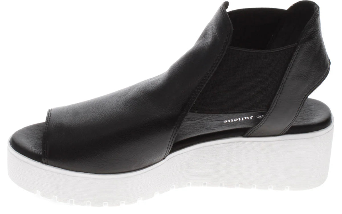 Black leather platform peep toe shoe with white sole.