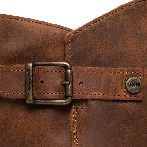 Close-up of a brown leather boot with a metal buckle and a branded button that reads 'D&H'.