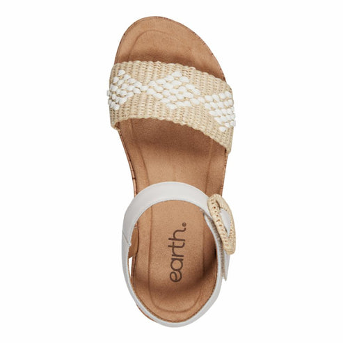 Overhead view of a sandal with a thick woven beige and white beaded strap and a white ankle strap with an earth. branded buckle.