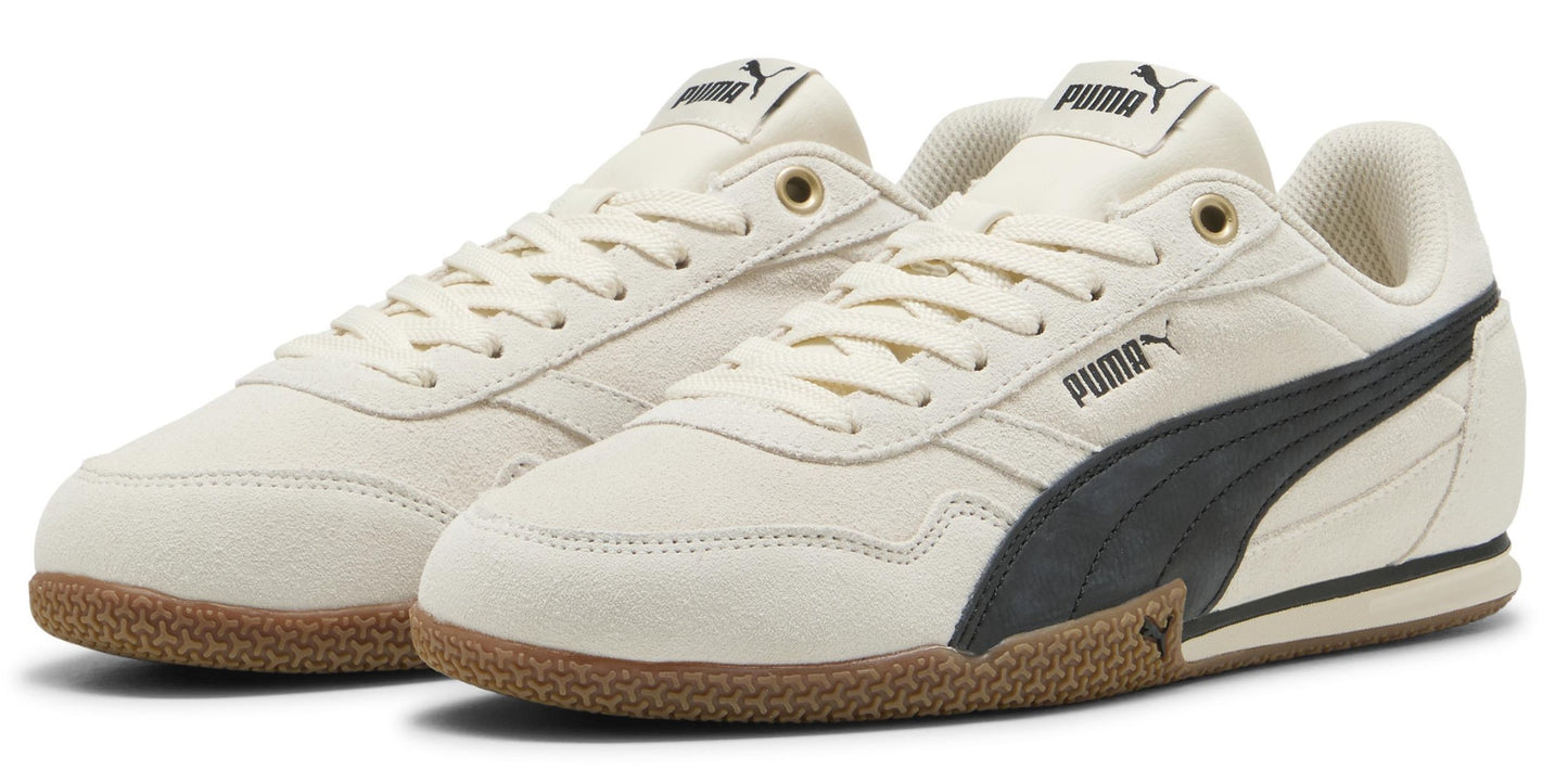 A pair of low-top, off-white sneakers with brown soles and a dark-colored logo.