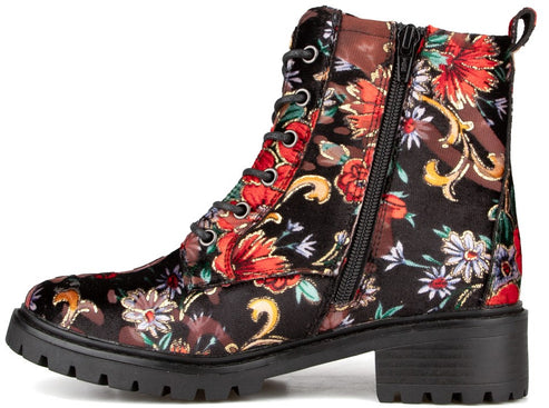 A black ankle boot with a floral pattern of red, white, yellow, and blue flowers, featuring a lace-up front, a side zipper, and a thick, lugged black rubber sole.