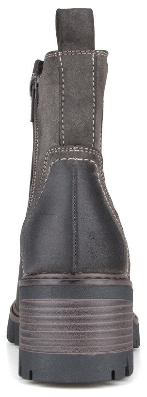 A rear-facing view of a dark grey ankle boot featuring a chunky, ribbed heel and a lug sole, with visible stitching detail and a pull tab at the top.