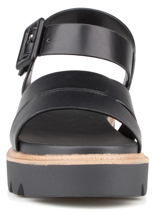 Black platform sandal with buckle strap.