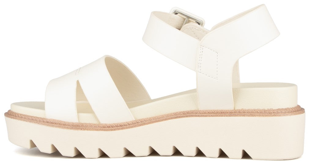 White sandal with adjustable ankle strap and lug sole.