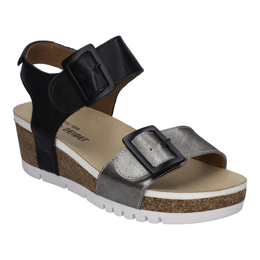 Wedge sandal with a black strap and buckle around the ankle and a metallic silver strap and buckle across the toes.