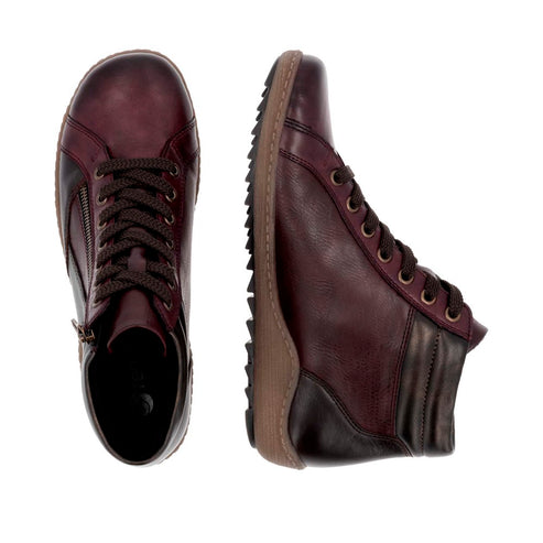 Pair of maroon leather boots, one upright and one on its side.