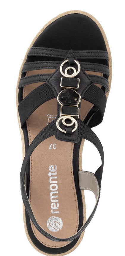 Black sandal with decorative circles.