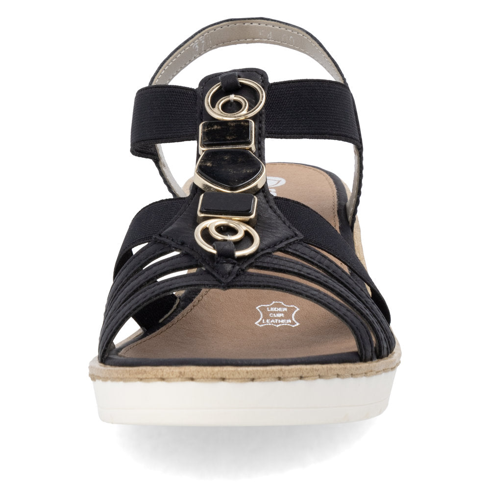 Black sandal with gold ring embellishments, multiple straps, and a white platform sole.