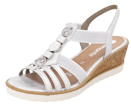 White wedge sandal with toe straps, decorative embellishments, and slingback strap.