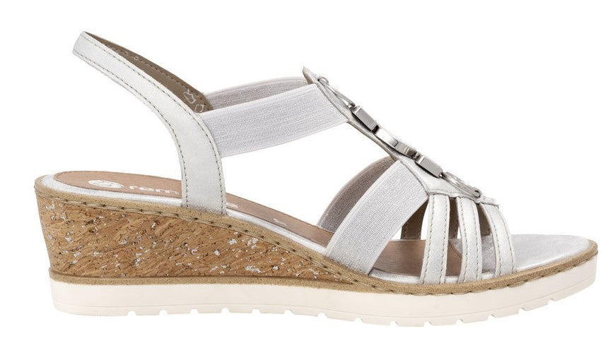 White wedge sandal with elastic straps and decorative metal accents.
