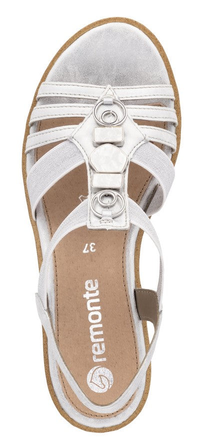 Silver sandal with multiple straps and circular metal accents.