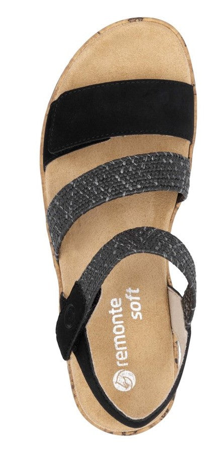 A sandal with black and gray straps. The insole has the word "remonte soft" on it.