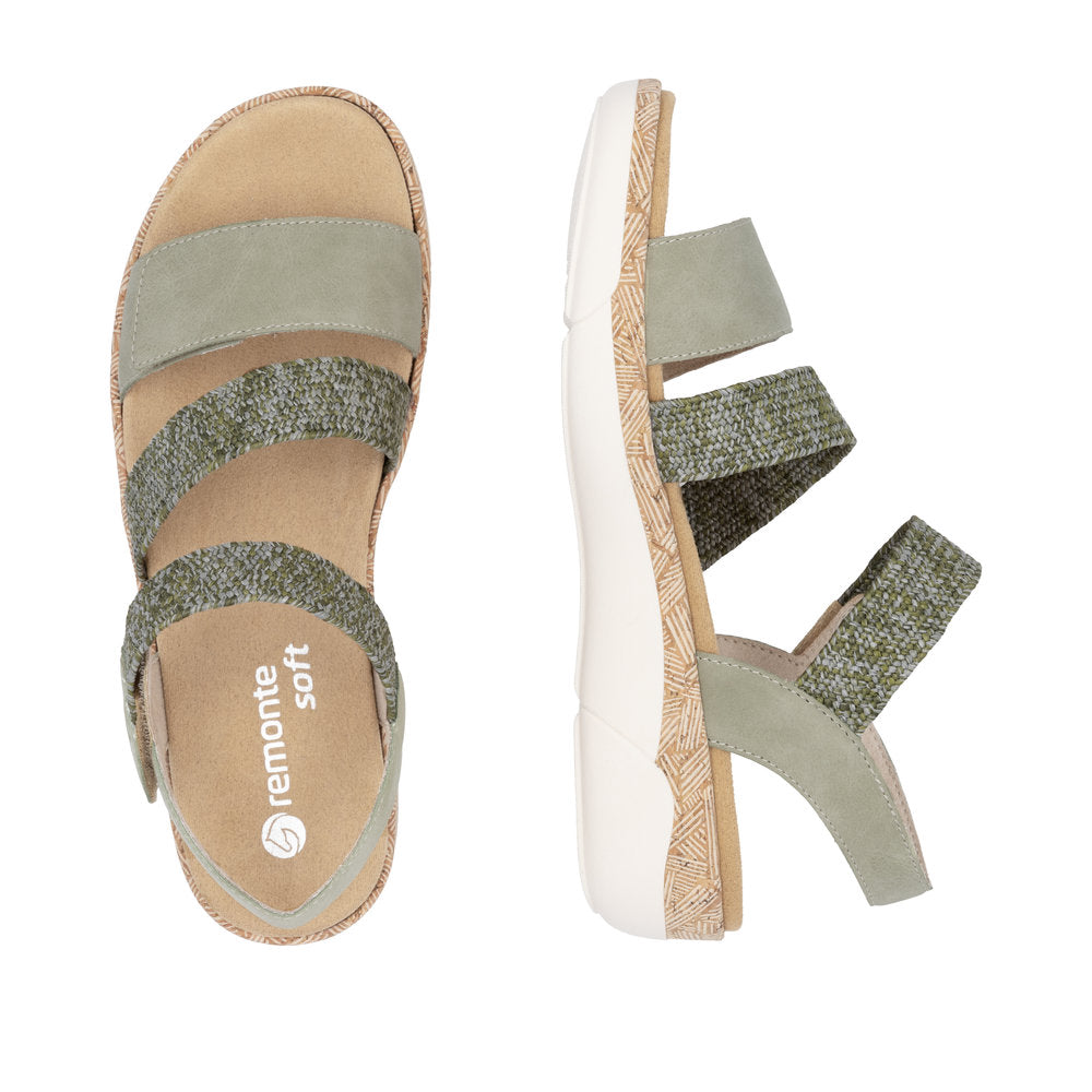 Two green and brown sandals, one facing up showing the insole, and one on its side, showing the outsole, with the insole of the first sandal saying "remonte soft"