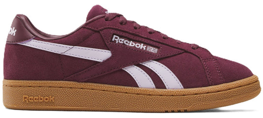 Burgundy low-top shoe with a gum sole and white stripes. The word "Reebok" is on the side.