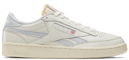 A sneaker in off-white with grey stripes.