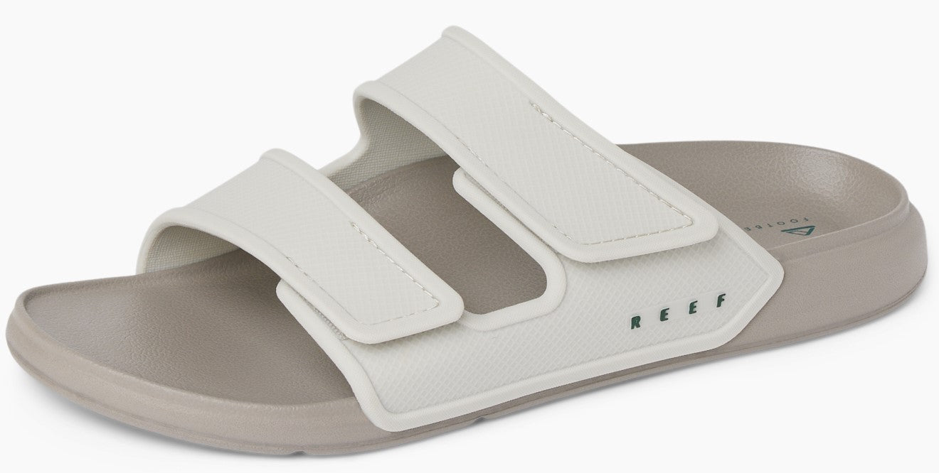 Slide sandal featuring two adjustable white straps and a neutral-colored sole.
