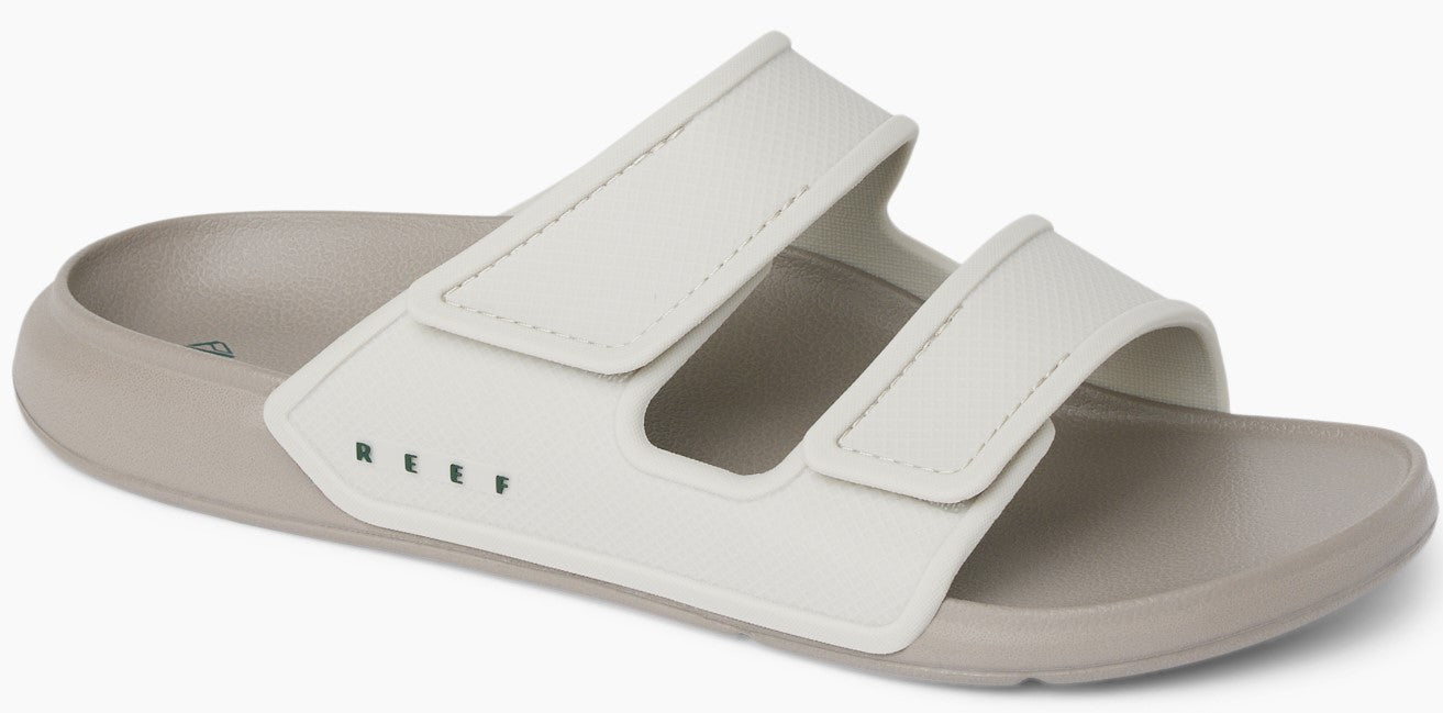 A sandal with two white velcro straps on a grey sole.
