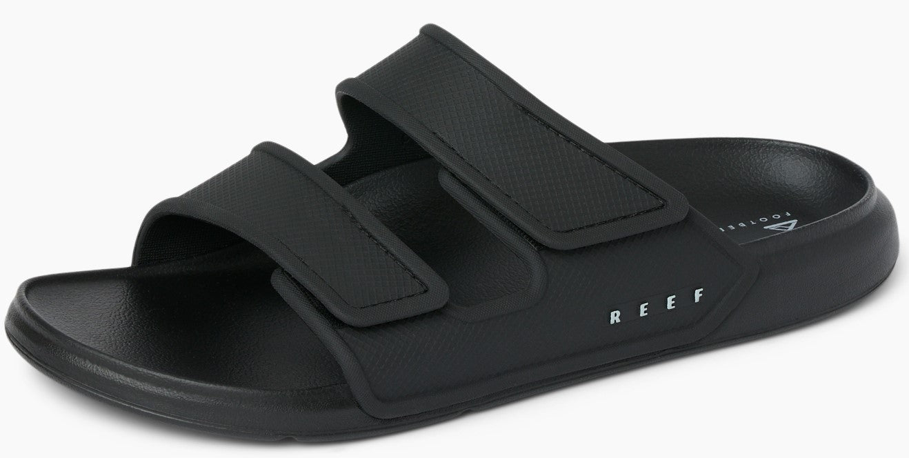 Black adjustable slide sandals with two velcro straps and white text "REEF".