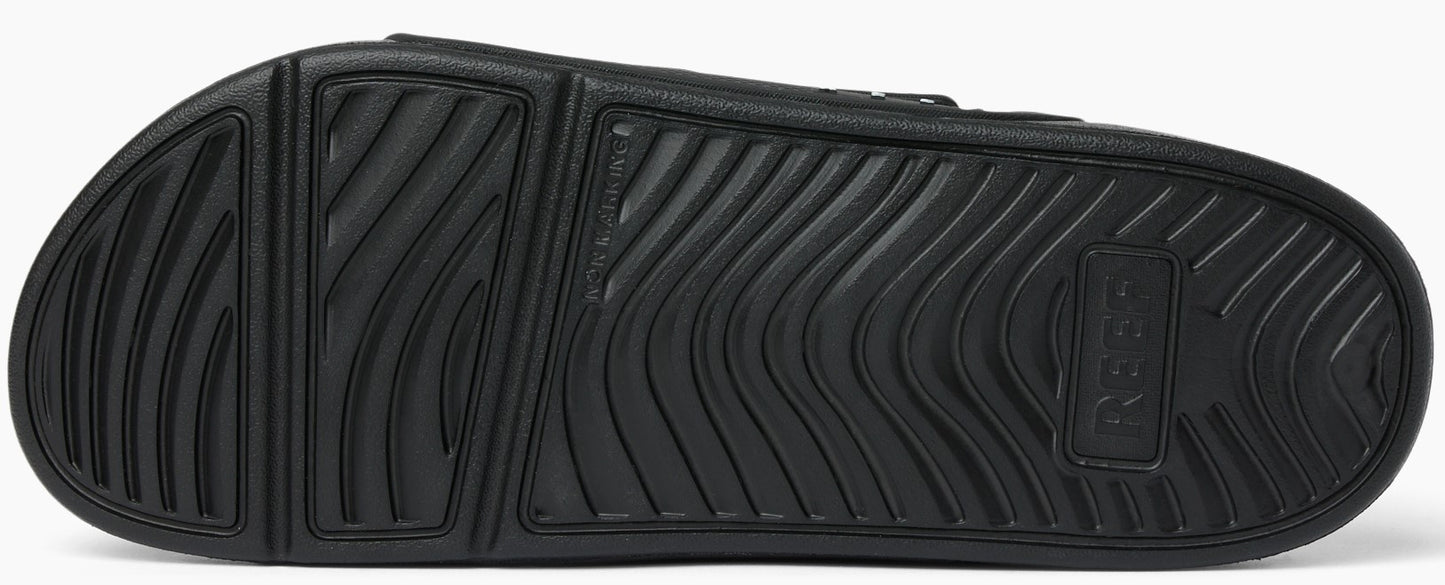 Black textured sole of a slide sandal.