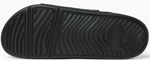 Black textured sole of a slide sandal.
