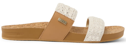 Sandals with two straps, one tan and one white, sitting on a cork insole.