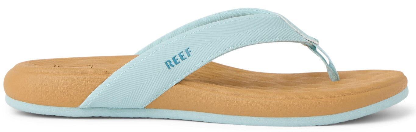 A flip-flop with a light blue strap, a tan insole, and a light blue outsole. The brand name "REEF" is printed on the strap.