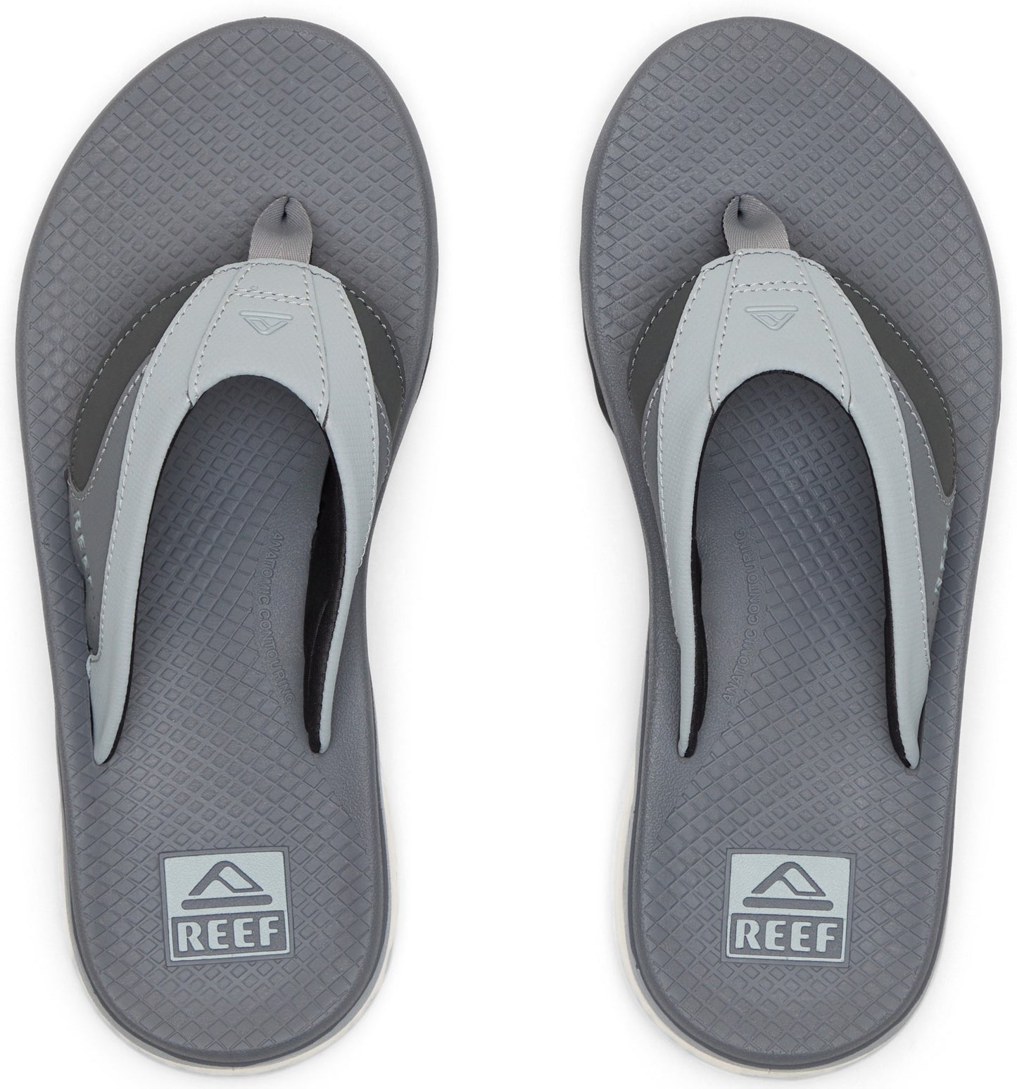 Gray flip-flops with white straps, soles featuring a textured diamond pattern and "REEF" logo.