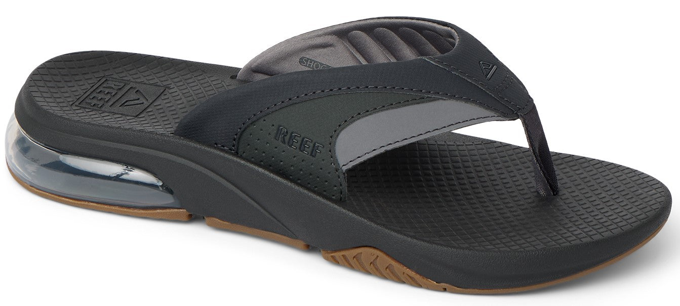 A black and gray flip-flop with a thick sole and a visible air bubble in the heel.