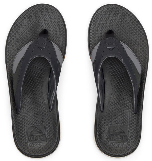 A pair of dark grey flip flops with textured footbed and grey straps, showing the brand logo on the footbed.