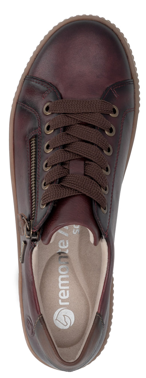 A top-down view of a dark brown leather women's sneaker with dark brown laces and a side zipper, featuring a light-colored, branded insole and a gum-colored textured rubber sole.