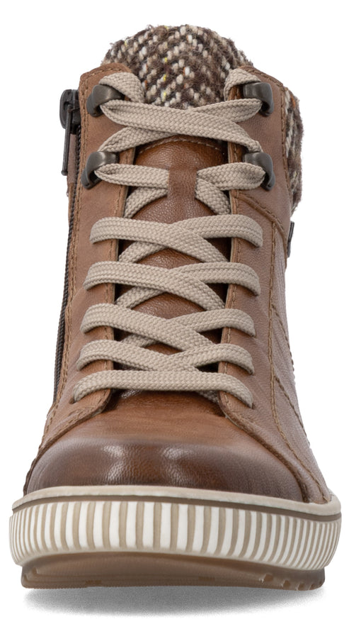 A brown leather ankle boot viewed from the front, featuring a white ribbed rubber sole, light-colored laces, dark metal eyelets, and a tweed-patterned knit collar.